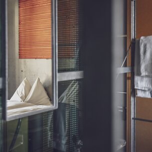 Spiegel im Hotelzimmer mit Sicht auf das Doppelbett | © Davos Klosters Mountains