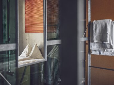 Spiegel im Hotelzimmer mit Sicht auf das Doppelbett | © Davos Klosters Mountains