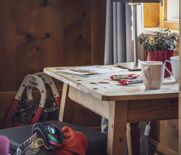 Schreibtisch im Hotelzimmer mit Schneeschuhen und Skibrille | © Davos Klosters Mountains