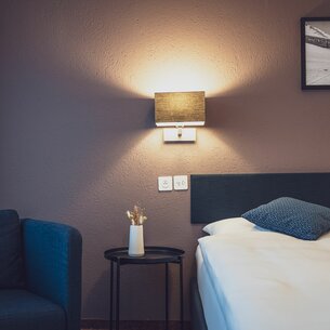 Hotelzimmer mit Sessel und Bett | © Davos Klosters Mountains