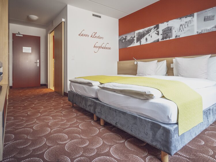 Doppelzimmer mit rotbraunem Interiour  | © Davos Klosters Mountains