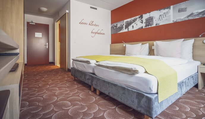 Doppelzimmer mit rotbraunem Interiour  | © Davos Klosters Mountains