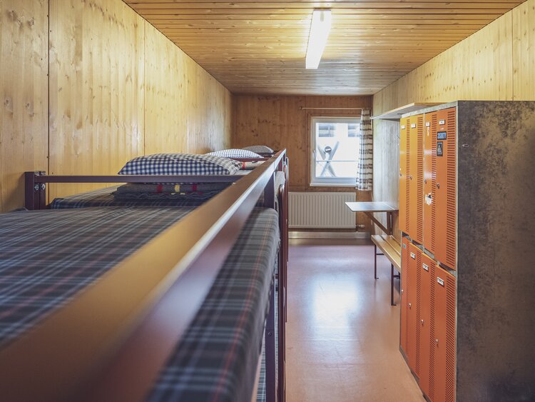 Zimmer mit mehreren Doppelstockbetten und Schliessfächern | © Davos Klosters Mountains 