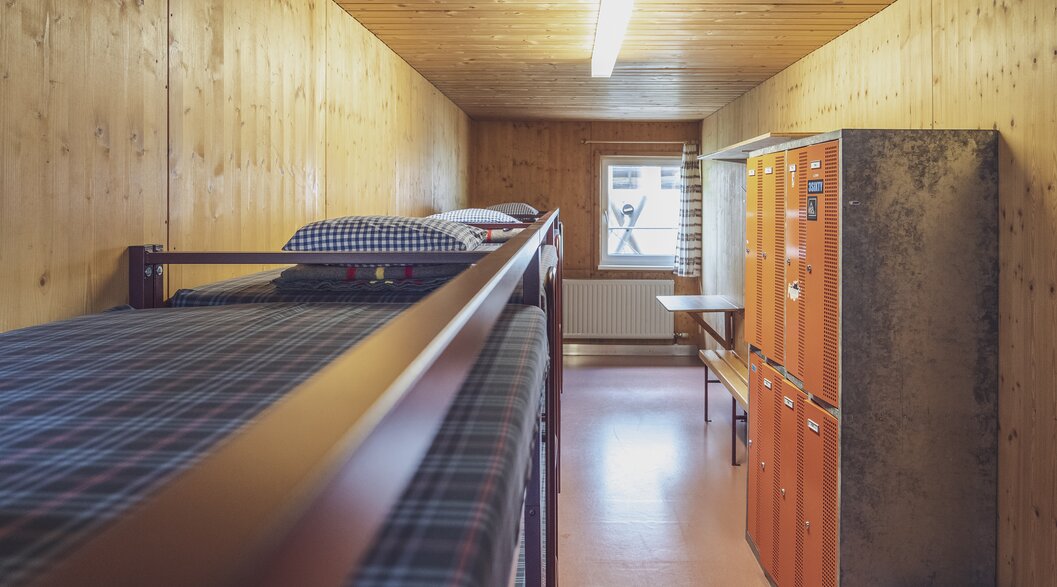 Room with multiple double bunk beds and lockers | © Davos Klosters Mountains 