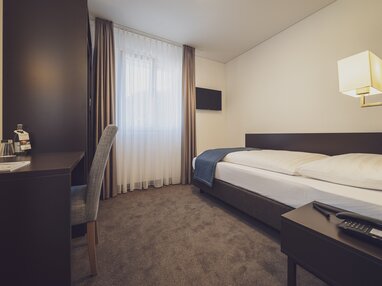 Moderns Einzelzimmer Comfort im Hotel Strela in warmen braun Tönen. | © Davos Klosters Mountains