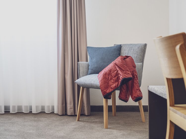 Interior Stuhl mit roter Jacke im Hotel Strala | © Davos Klosters Mountains