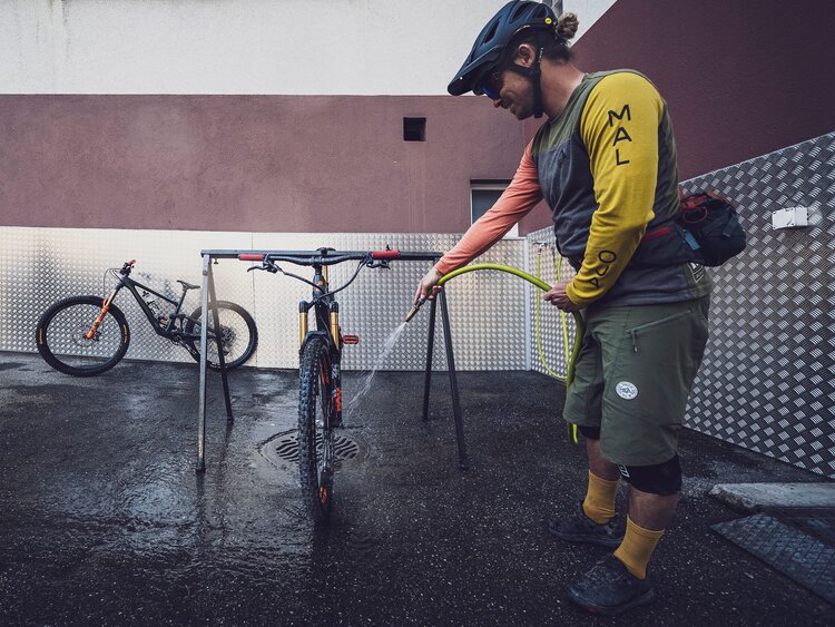 Biker beim Waschen seines Mountain Bikes am Waschplatz des Mountain Plaza Hotels Davos | © Davos Klosters Bergbahnen AG