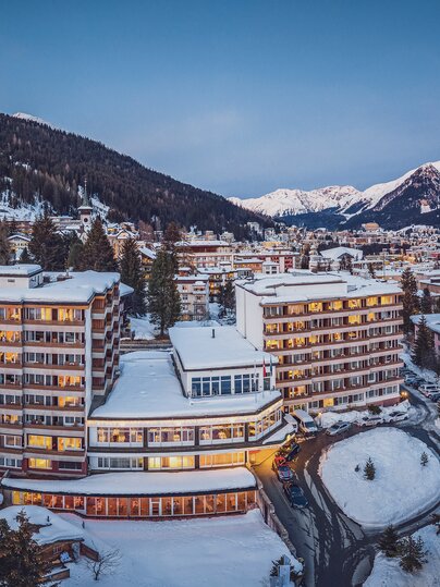 Beleuchtetes Mountain Plaza Hotel im Winter. | © Davos Klosters Mountains
