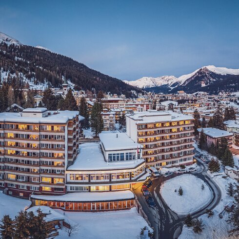 Beleuchtetes Mountain Plaza Hotel im Winter. | © Davos Klosters Mountains