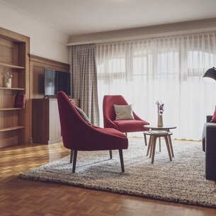 Wohnzimmer mit roten Sesseln und einr Couch | © Davos Klosters Mountains