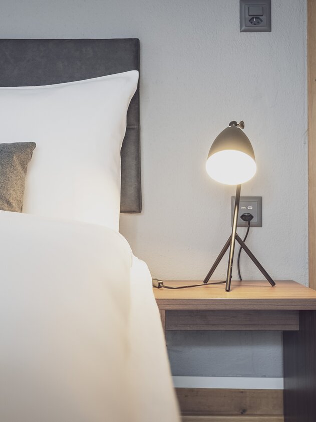 Bedroom with bed and bedside lamp | © Davos Klosters Mountains Bedroom with bed and bedside lamp | © Davos Klosters Mountains