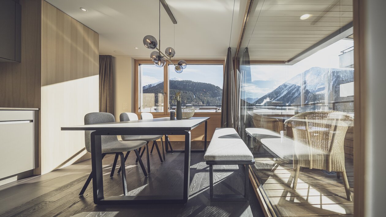 Grosser Esstisch mit grosser Glasfront und viel Aussicht auf die Berge | © Davos Klosters Mountains