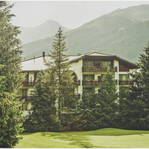 Mehrstöckiges Gebäude mit Balkonen umringt von Nadelbäumen  | © Davos Klosters Mountains 