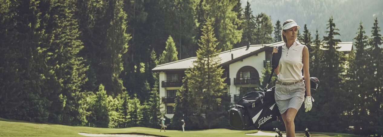Golfer on the lawn with hotel in the background | © Davos Klosters Mountains