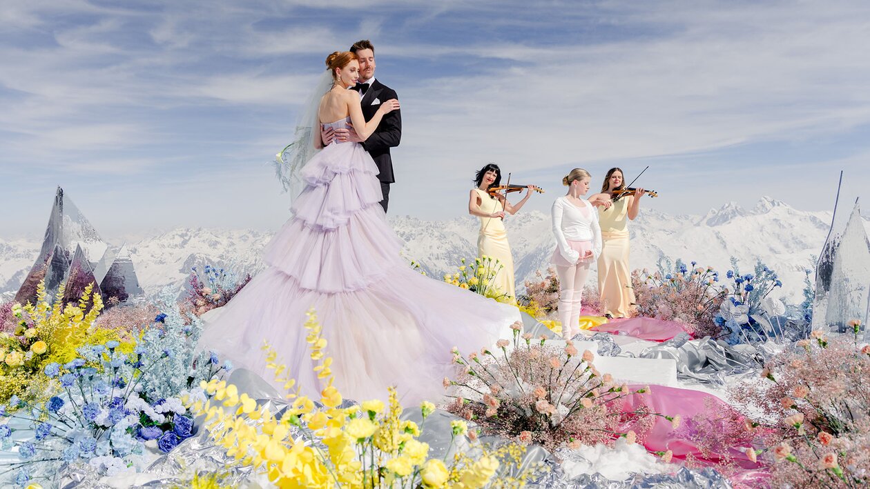Traumhaftes Hochzeitssetting mit Brautpaar, Tänzerin, zwei Geigerinnen und bunten Blumen am Weissfluhgipfel Davos | © The Tailors Photography | Julia Schneider-Reissle