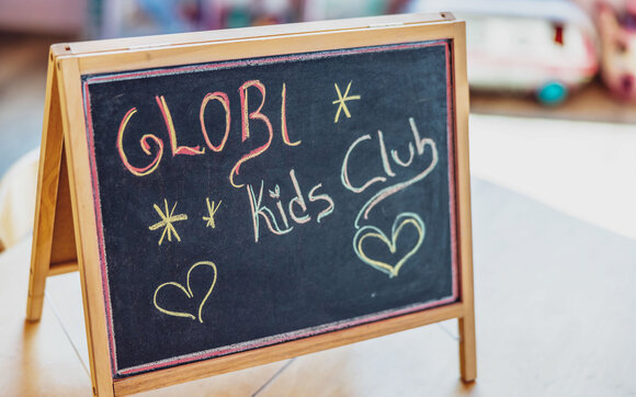 Auf einer schwarzen Tafel steht mit Kreide Globi Kids Club. | © DDO - davos.ch | Martin Bissig