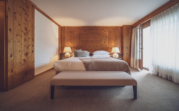 Doppelbettzimmer mit Bettwäsche, Nachttischlämpchen und Kleiderbank  | © Davos Klosters Mountains 
