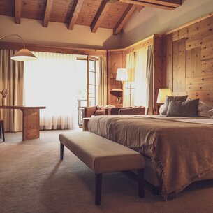 Grosses Hotelzimmer mit viel Holz und Doppelbett | © Davos Klosters Mountains