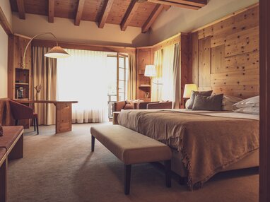 Grosses Hotelzimmer mit viel Holz und Doppelbett | © Davos Klosters Mountains