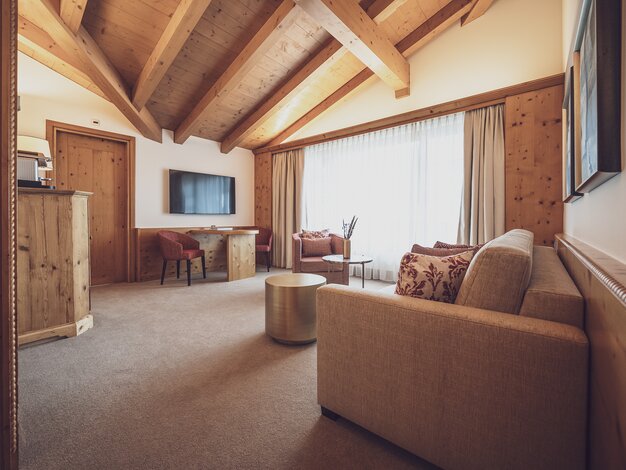 Hotelzimmer mit viel Holz und Couch | © Davos Klosters Mountains