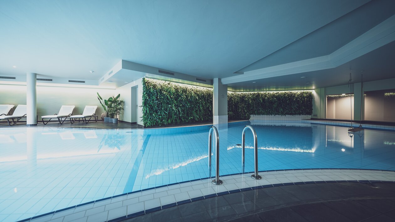 Indoorpool beleuchtet mit Ruheliegen | © Davos Klosters Mounains 