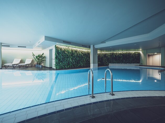 Indoorpool beleuchtet mit Ruheliegen | © Davos Klosters Mounains 