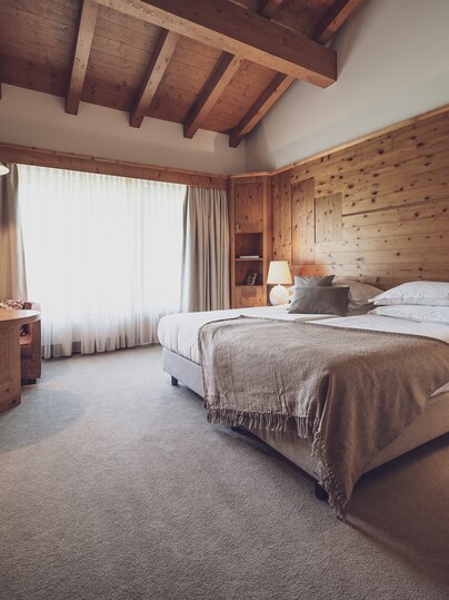 Grosszügiges Doppelbettzimmer komplett mit Holz ausgestattet | © Davos Klosters Mountains 