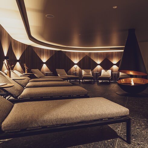 Gemütlicher Ruheraum mit modernem Kamin im Wellnessbereich vom Hotel Waldhuus Davos. | © Davos Klosters Mountains