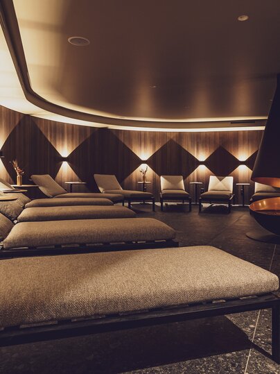 Gemütlicher Ruheraum mit modernem Kamin im Wellnessbereich vom Hotel Waldhuus Davos. | © Davos Klosters Mountains