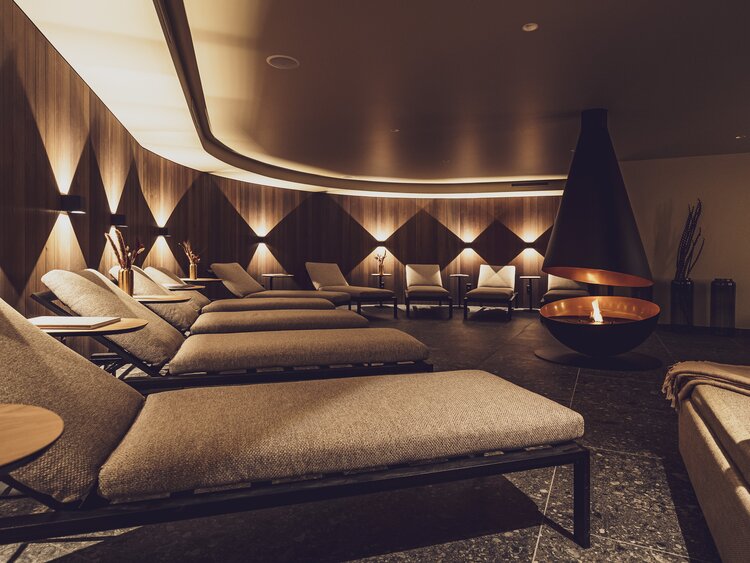 Gemütlicher Ruheraum mit modernem Kamin im Wellnessbereich vom Hotel Waldhuus Davos. | © Davos Klosters Mountains