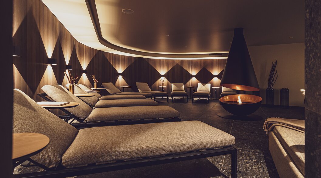 Gemütlicher Ruheraum mit modernem Kamin im Wellnessbereich vom Hotel Waldhuus Davos. | © Davos Klosters Mountains