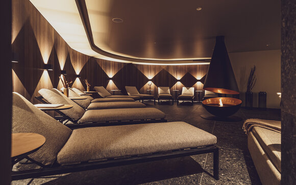 Gemütlicher Ruheraum mit modernem Kamin im Wellnessbereich vom Hotel Waldhuus Davos. | © Davos Klosters Mountains