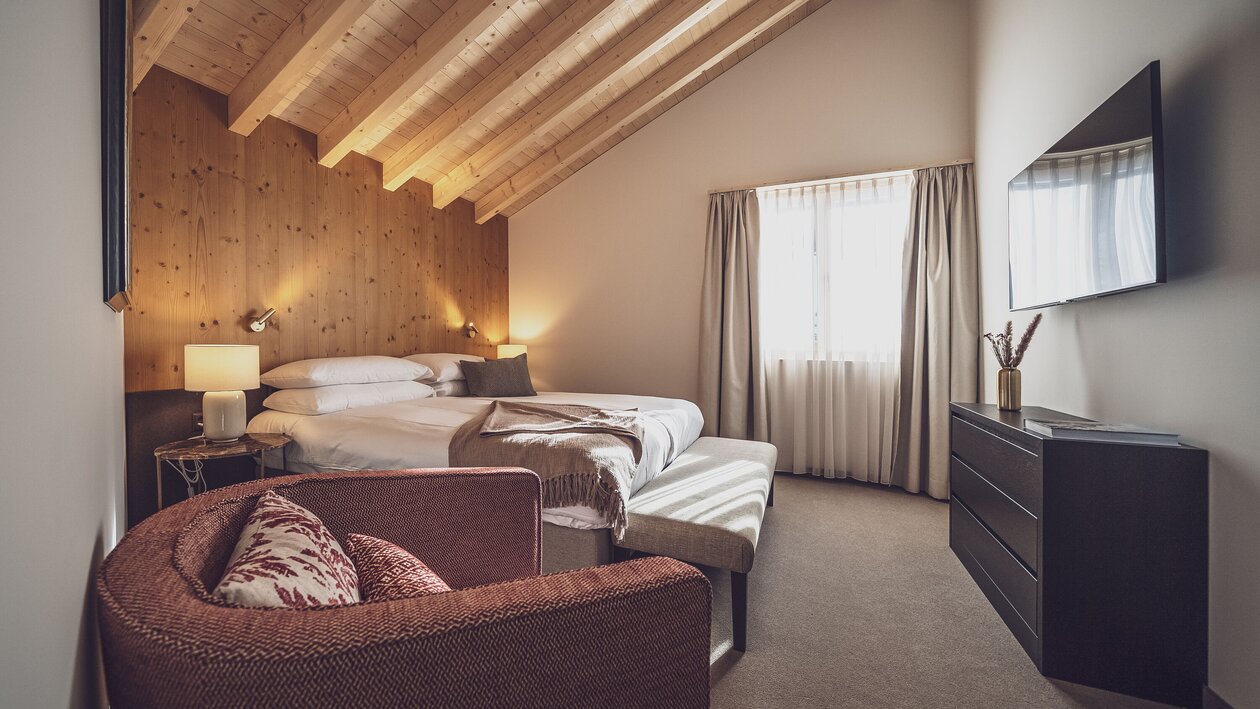 Blick in die helle Senior Suite im Hotel Waldhuus, die in warmen Tönen ausgestattet ist. | © Davos Klosters Mountains