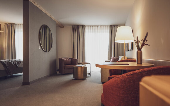 Hotelzimmer mit Salontisch, Vorhängen und Stehlampe  | © Davos Klosters Mountains 