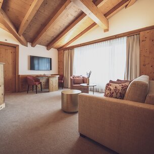 Hotel room with lots of wood and couch | © Davos Klosters Mountains