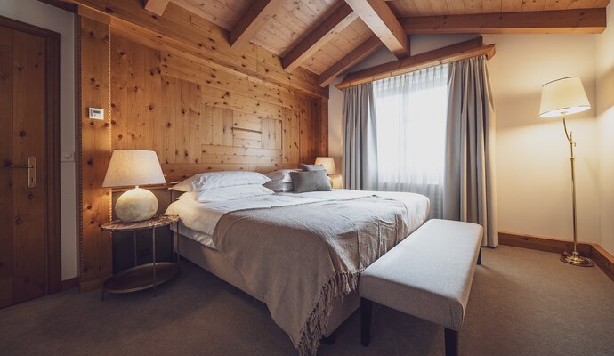Schlafzimmer mit Doppelbett und viel Holz | © Davos Klosters Mountains